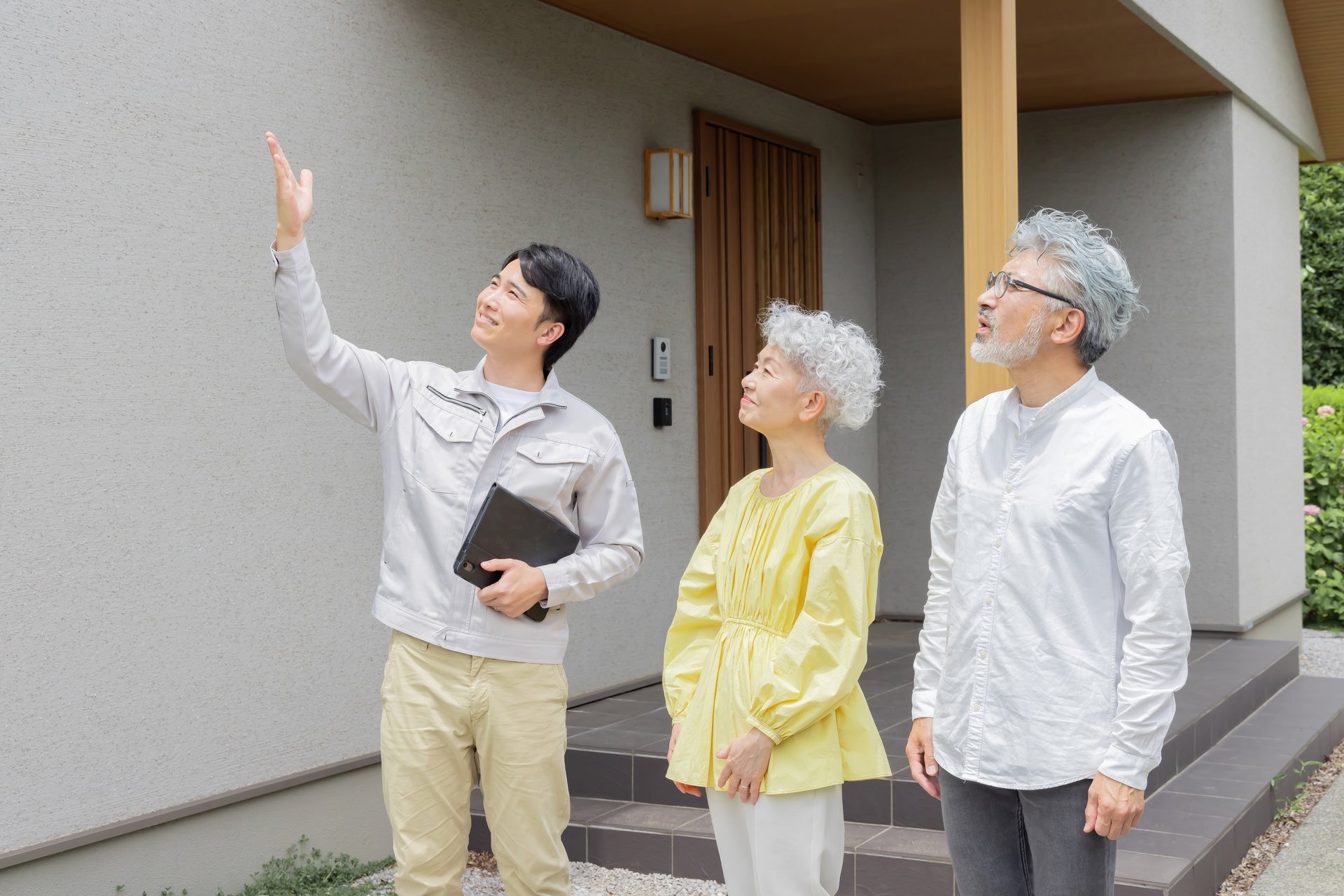 牛久市 住宅の前で説明する作業員とご夫婦 イメージ